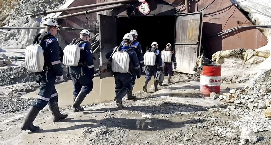 In this handout photo taken from video released by Russia Emergency Situations Ministry press service on Thursday, March 21, 2024, Russia Emergency Situations employees walk to the collapsed gold mine ...