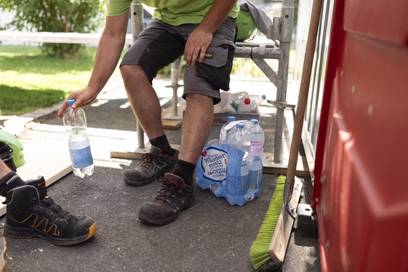 KEYPIX - Dachdecker der Firma Greencover AG trinken Wasser und machen eine kurze Pause im Schatten um 15 Uhr und nennen diese Hydratation break, fotografiert am Mittwoch, 24. Juni 2026 in Mels (KEYSTO ...