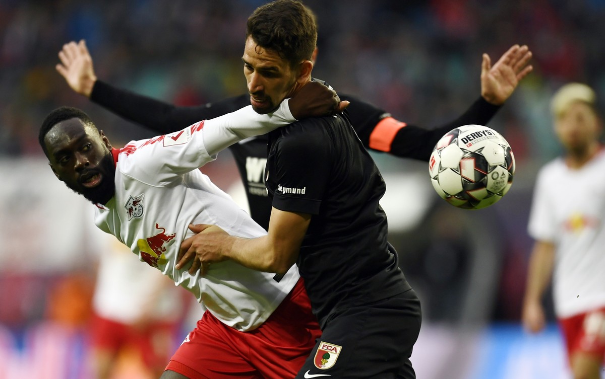 epa07425035 Leipzig's Jean-Kevin Augustin (L) and Augsburg's Rani Khedira in action during the German Bundesliga soccer match between RB Leipzig and FC Augsburg, in Leipzig, Germany, 09 Marc ...