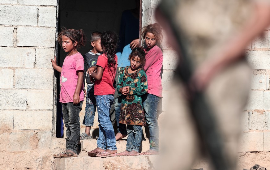 epa07827256 Children watch from their house while Turkish soldiers patrol near Turkish-Syria border near Akcakale district in Sanliurfa, Turkey, 08 September 2019. Turkey and the US began joint patrol ...