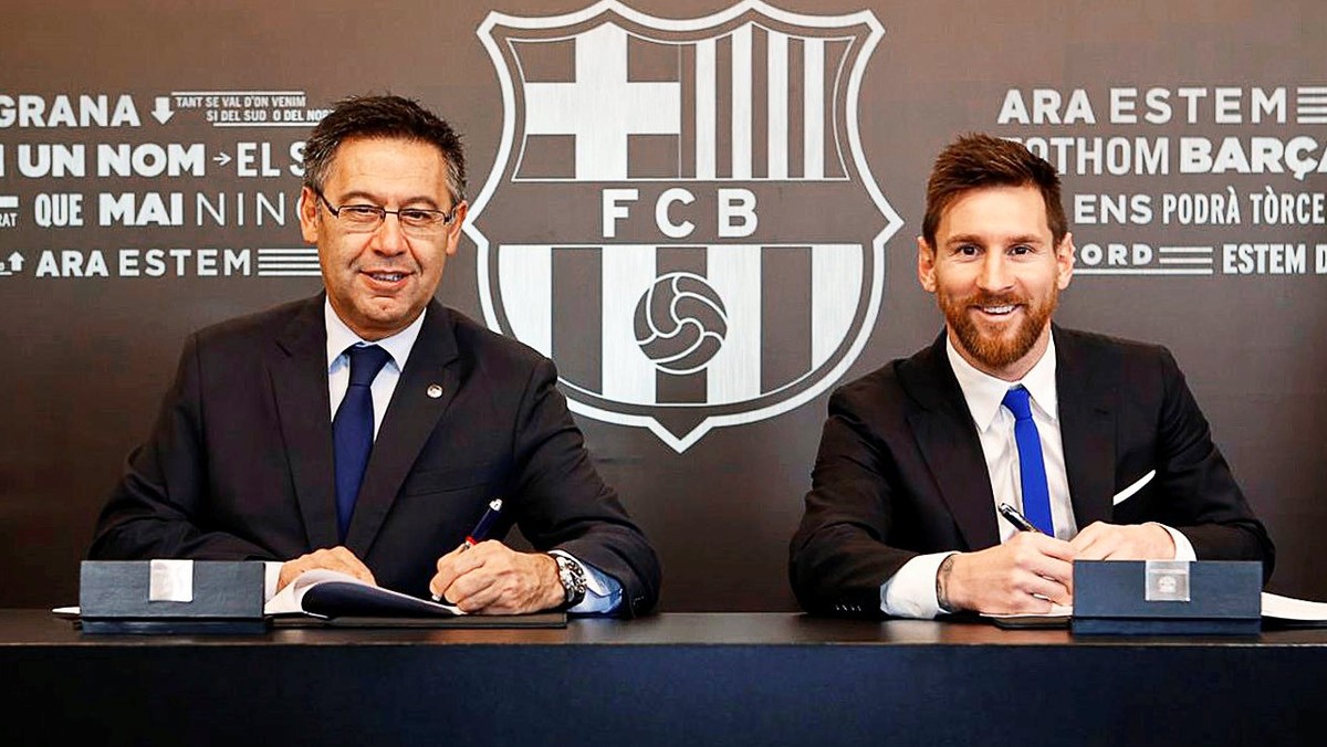 epa06349647 A handout photo made available by Spanish Primera Division soccer club FC Barcelona of Argentine striker Lionel Messi (R) signing his new contract next to Barcelona's president Josep  ...