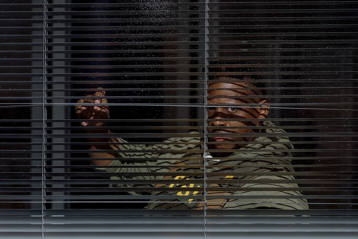 epa12689301 A Federal Bureau of Investigation (FBI) agent peers out a window as the FBI conducts a 'court-ordered search warrant' at the Fulton County Department of Registration and Election ...