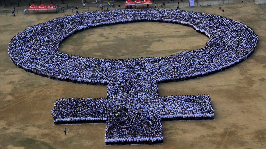 epa04114806 A handout photo provided by the Philippine Airfor Public Information Office (PAF-IPO) shows thousands of Filipinos forming a large human women symbol at the Quirino Grandstand in celebrati ...