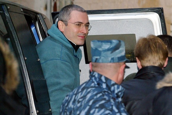 FILE - Mikhail Khodorkovsky, the former chief of Russia&#039;s largest oil company, Yukos, leaves an armored police car, as he is escorted to a court in Moscow, on Dec. 22, 2003. Khodorkovsky, who is  ...