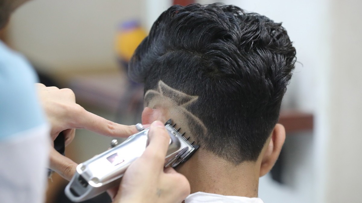 epa10005808 A customer receives a haircut at a barbershop in Khusus district, Cairo, Egypt, 29 May 2022 (issued 10 June 2022). In recent years &amp;#039;weird&amp;#039; haircuts and hairstyles inspire ...