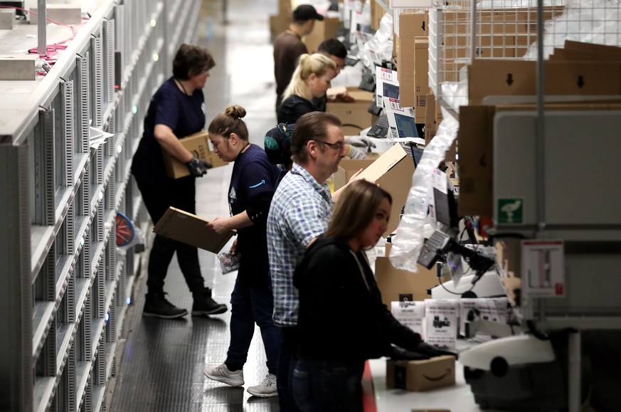 epa08077438 Employees works at the Amazon logistic and distribution center in Moenchengladbach, Germany, 17 December 2019. According to the company, Amazon has invested around 105 million euros in the ...