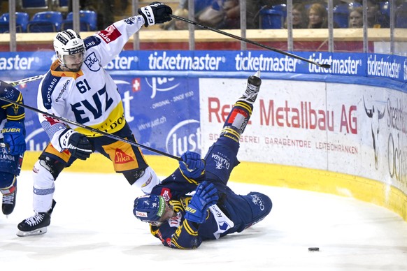 Der Zuger Sven Leuenberger, links, gegen den Davoser Enzo Corvi, im zweiten Eishockey Playoff-Halbfinalspiel der National League zwischen dem HC Davos und dem EV Zug, am Sonntag, 10. April 2022, im Ei ...