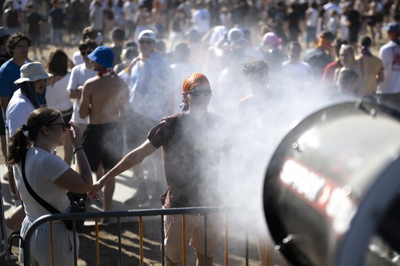 Besucher kuehlen sich im Wasser einer Regenmaschine am Openair Frauenfeld, am Freitag, 10. Juli 2026, in Frauenfeld. (KEYSTONE/Gian Ehrenzeller)