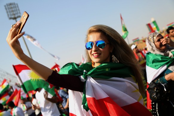 epa06220473 A Kurdish woman takes a selfie during a rally for the Kurdistan independence referendum campaign at the Franso Hariri stadium in Erbil, Iraq, 22 September 2017. Kurdish leaders take the fi ...