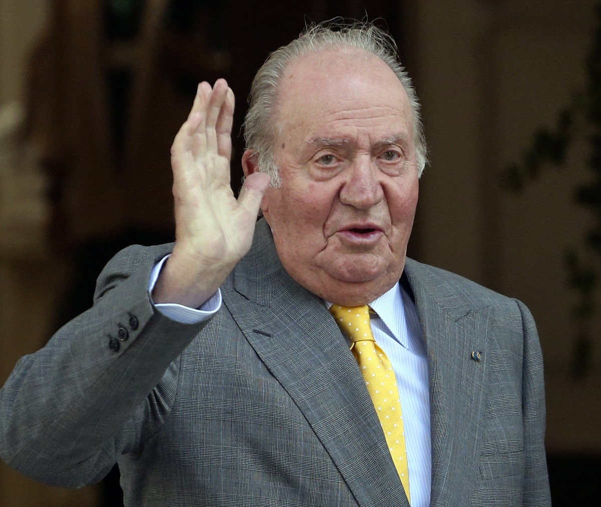 FILE - Spain's emeritus King Juan Carlos waves upon his arrival to the Academia Diplomatica de Chile, in Santiago where he met with President-elect Sebastian Pinera, on March 10, 2018. Geneva pro ...