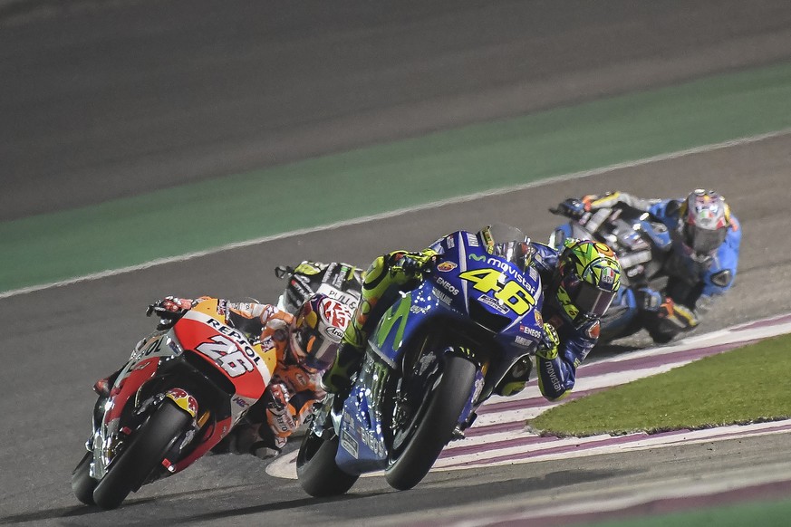 Italian MotoGP rider Valentino Rossi and Spanish rider Dani Pedrosa of the Repsol Honda Team make their way during the Moto GP World Championship race at the Losail International Circuit in Doha, Qata ...