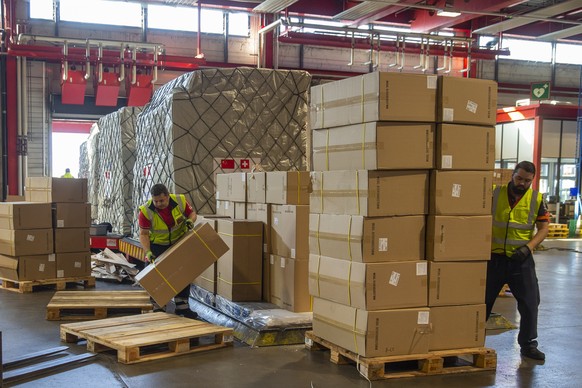 Workers of Swissport move boxes of medical supplies for to dispatch to hospitals, at the Freet area of the Geneve Aeroport, in Geneva, Switzerland, Monday, April 6, 2020. An aircraft of Cargolux carri ...