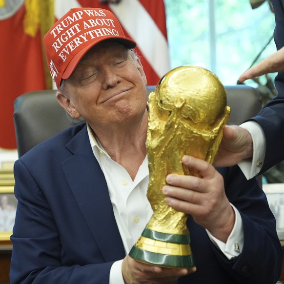 KEYPIX - President Donald Trump holds the FIFA World Cup Winners Trophy during an announcement in the Oval Office of the White House, Friday, Aug. 22, 2025, in Washington. (AP Photo/Jacquelyn Martin)