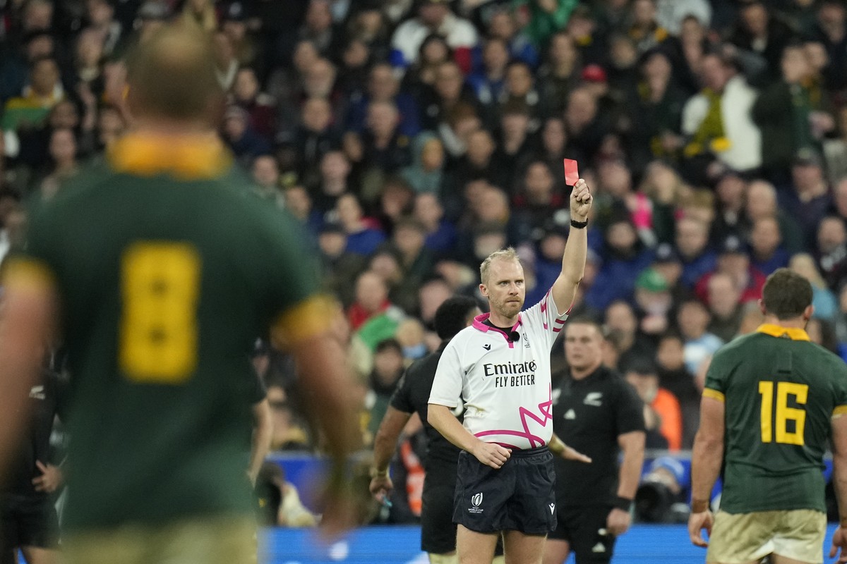 Referee Wayne Barnes holds up a red card to show that the video judge has upgraded a yellow to red for New Zealand's Sam Cane during the Rugby World Cup final match between New Zealand and South  ...