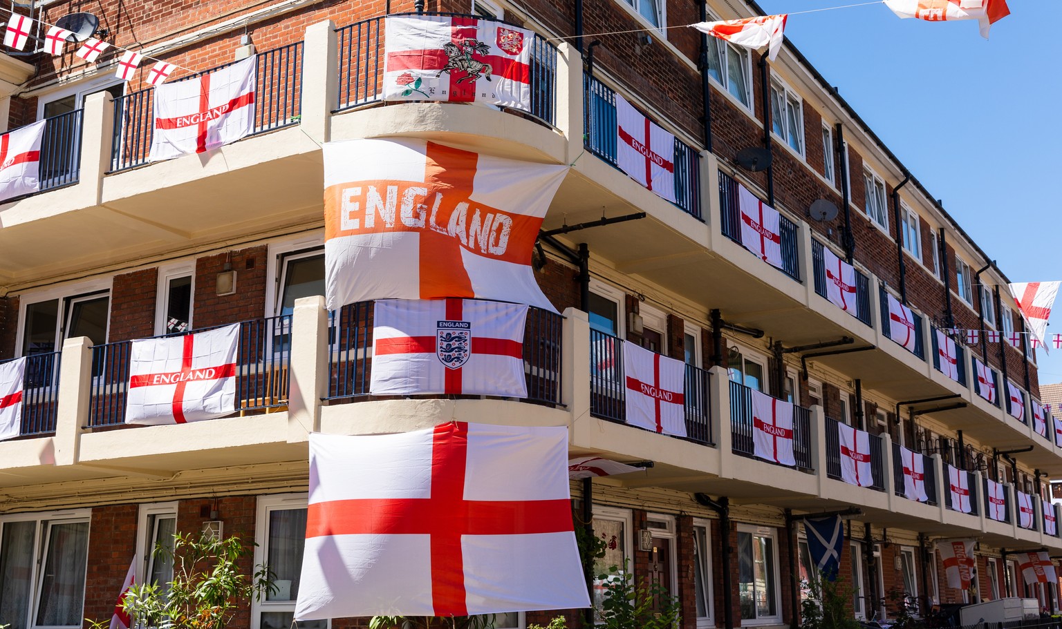 epa09257967 England flags fly from residential flats on the Kirby Estate in Bermondsey, London, Britain, 09 June 2021. The UEFA EURO 2020 soccer tournament was delayed by a year because of the Covid-1 ...