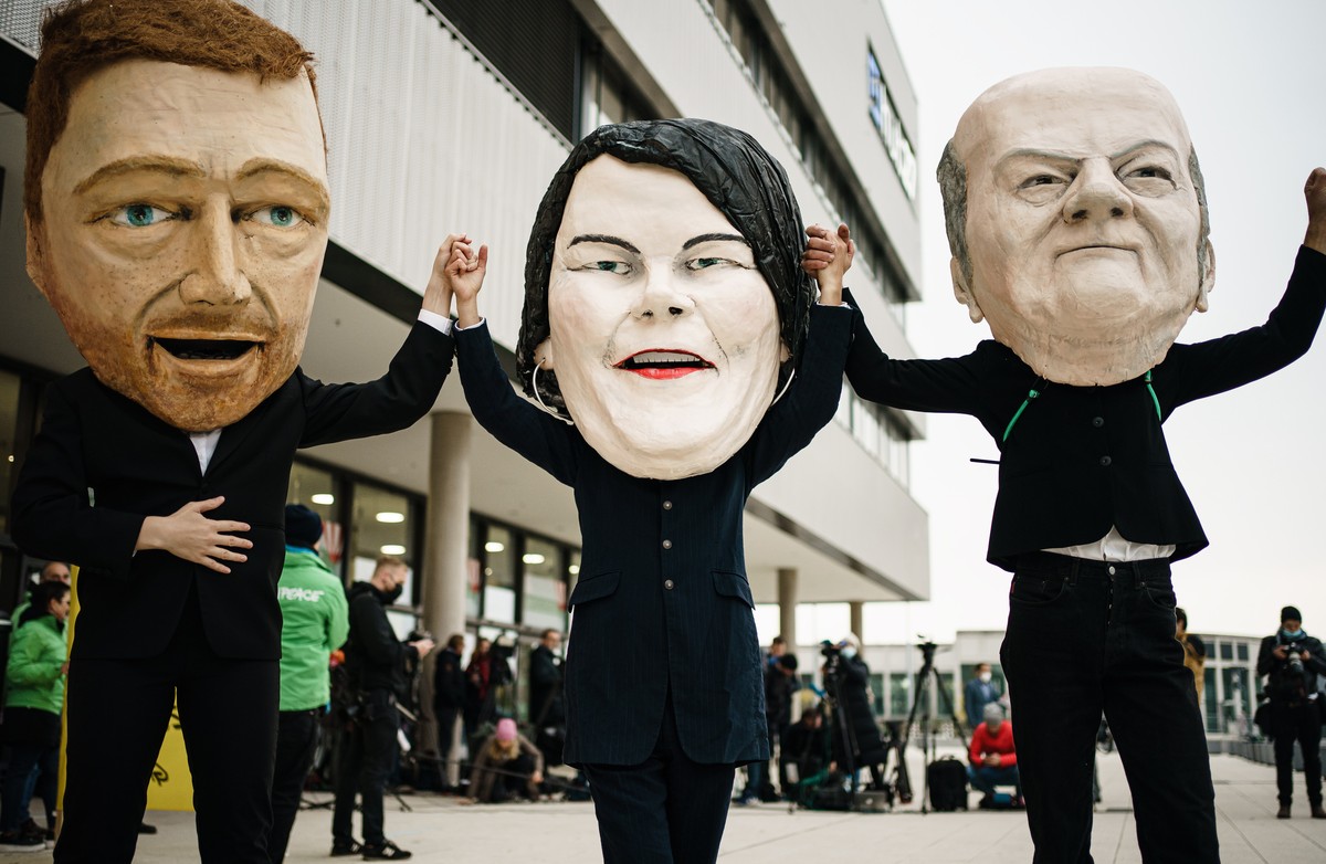 epaselect epa09518123 Activists of Campact wearing masks resembling (L-R) Free Democratic Party (FDP) chairman and faction chairman in the German parliament Bundestag Christian Lindner, Green party (D ...