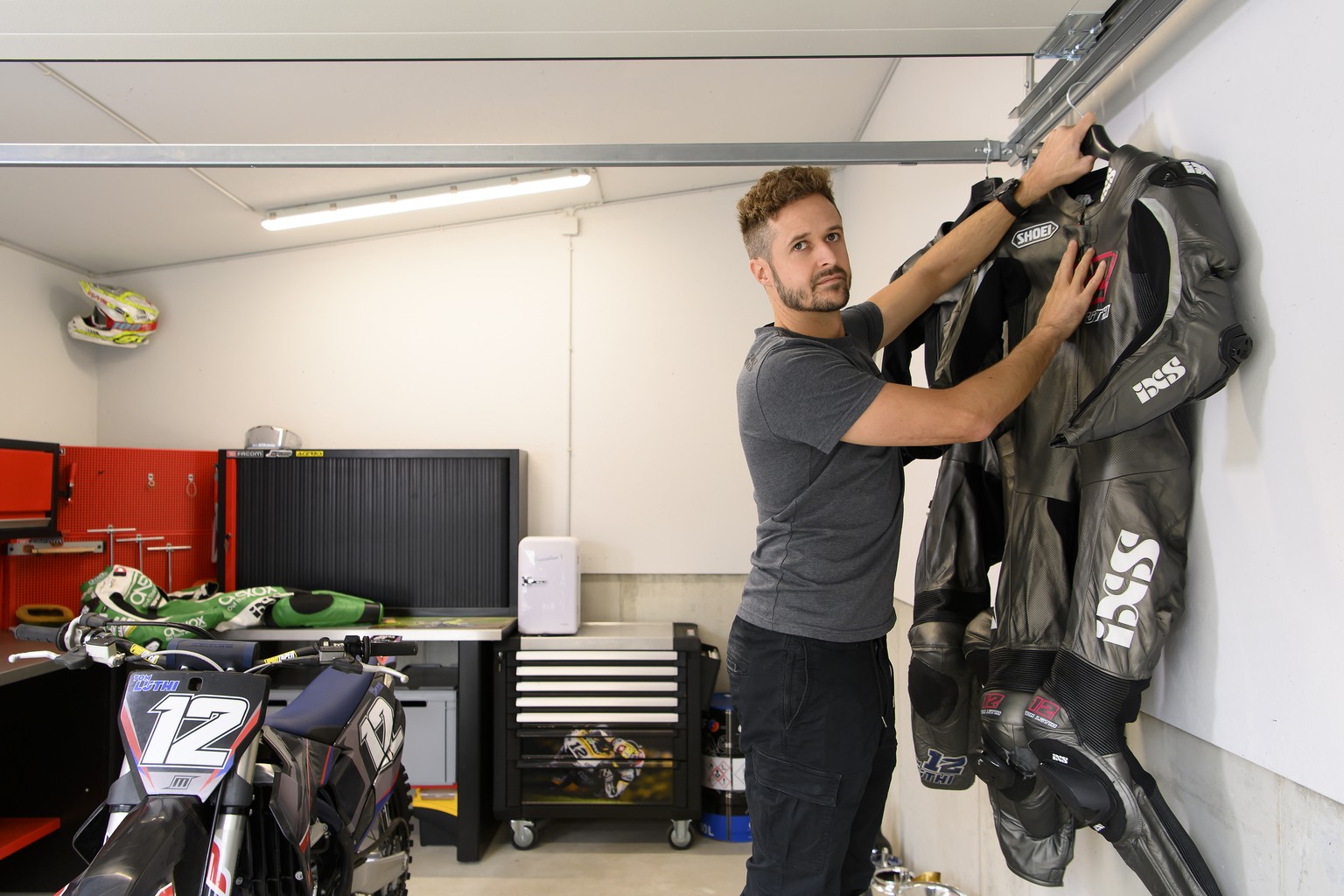 Swiss motorcycle racer Thomas &quot;Tom&quot; Luethi, hangs his motorcycle suits during a media appointment at his home in Linden, Switzerland, on Thursday, August. 19 2021. Luethi is retiring at the  ...