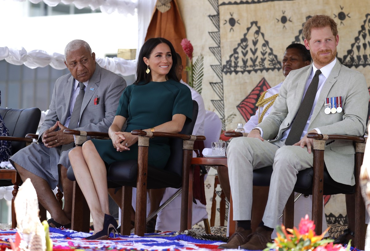 Britain's Prince Harry, right, and Meghan, Duchess of Sussex sit with Fiji's Prime Minister Frank Bainimarama during an official ceremony in Nadi, Fiji, Thursday, Oct. 25, 2018. Britain' ...