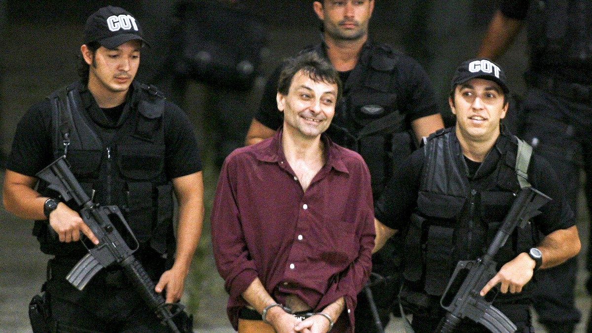 FILE - This March 19, 2007 file photo, shows Italian leftist fugitive activist Cesare Battisti, center, as he is escorted by Federal Police officers upon his arrival at Brasilia's airport. Brazil ...
