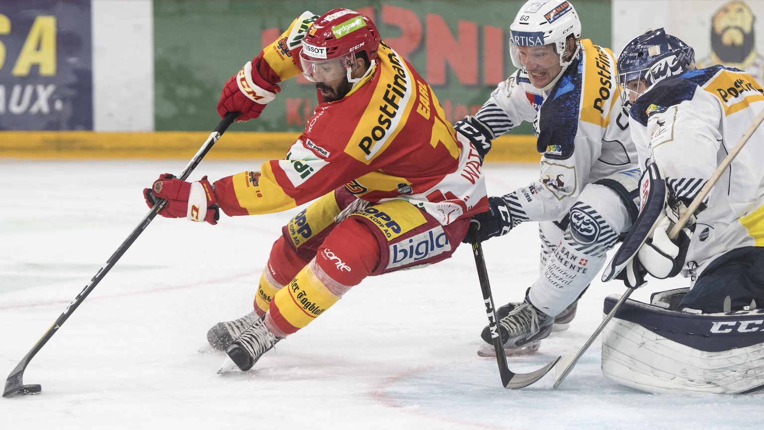 Biels Robbie Earl, links, im Duell mit Ambris Franco Collenberg, Mitte, und Torhueter Benjamin Conz im Eishockey Meisterschaftsspiel der National League zwischen dem EHC Biel und dem HC Ambri-Piotta,  ...