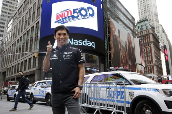 Takuma Sato, the 2017 Indianapolis 500 winner, poses for photos after ringing the opening bell at the Nasdaq MarketSite, in New York&#039;s Times Square, Tuesday, May 30, 2017. (AP Photo/Richard Drew)