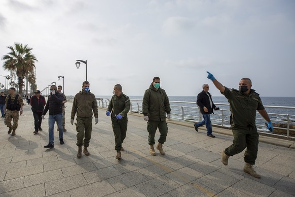 Municipal policemen order people to evacuate the corniche, or waterfront promenade, along the Mediterranean Sea, as the country&#039;s top security council and the government were meeting over the spr ...