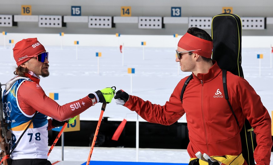 epa12734172 Jeremy Finello of Switzerland greets teammate Niklas Hartweg at the shooting range during the zeroing before the Men's 10km Sprint of the Biathlon competitions at the Milano Cortina 2 ...