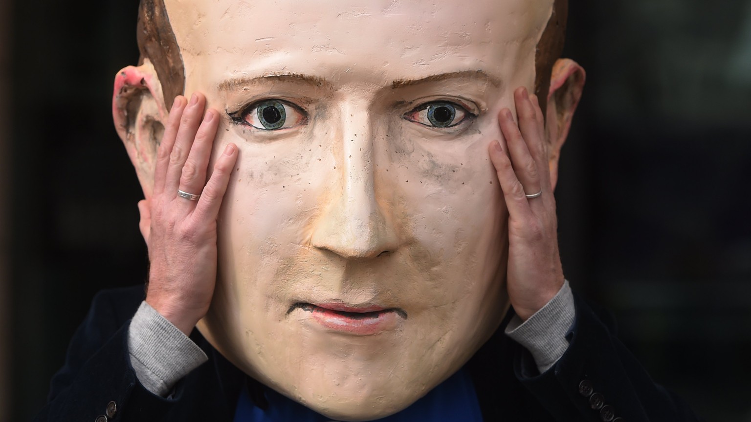 epa06693774 A protester wearing a mask depicting Facebook&#039;s CEO, Mark Zuckerberg, protest outside Portcullis House in central London, Britain, 26 April 2018. Facebook’s CTO Mike Schroepfer&#039;s ...