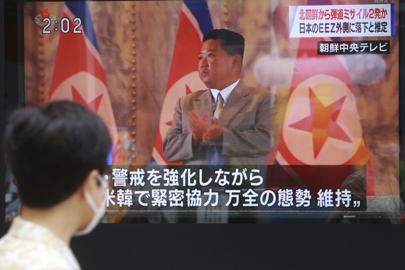 A man walks past a TV screen showing North Korean leader Kim Jong Un, in Tokyo, Wednesday, Sept. 15, 2021. North Korea fired two ballistic missiles into waters off its eastern coast Wednesday afternoo ...