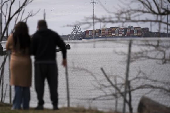 People view the container ship as it rests against wreckage of the Francis Scott Key Bridge on Tuesday, March 26, 2024, as seen from Dundalk, Md. The ship rammed into the major bridge in Baltimore ear ...