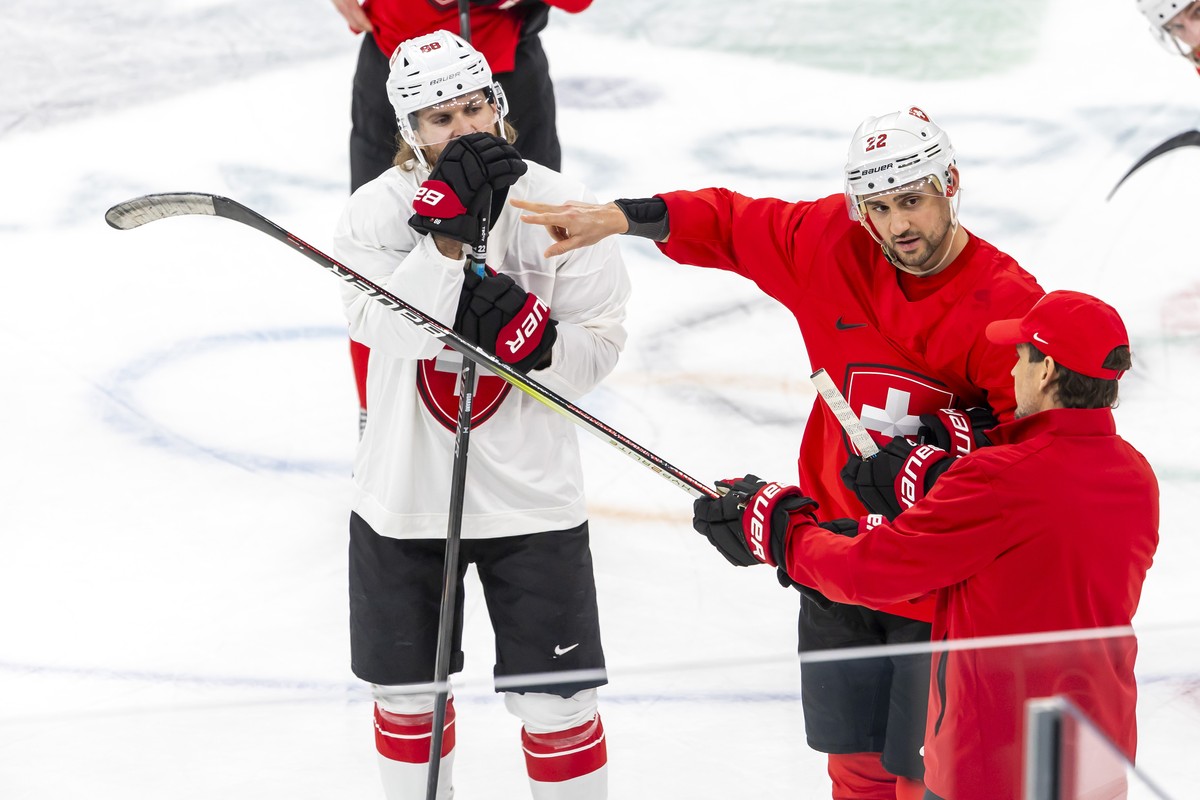 epa12717498 Patrick Fischer, (R) head coach of Switzerland national ice hockey team, speaks with Switzerland's Nino Niederreiter, (C) past Switzerland's Christoph Bertschy, (L) during a trai ...