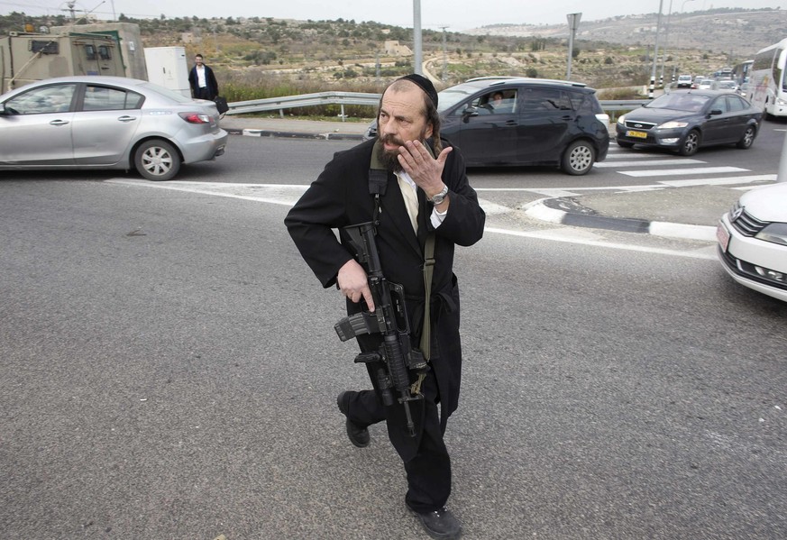 Ein bewaffneter ultraorthodoxer Jude rennt zum Tatort. Der Säureanschlag wurde nahe der jüdischen Siedlung Neve Daniel verübt.