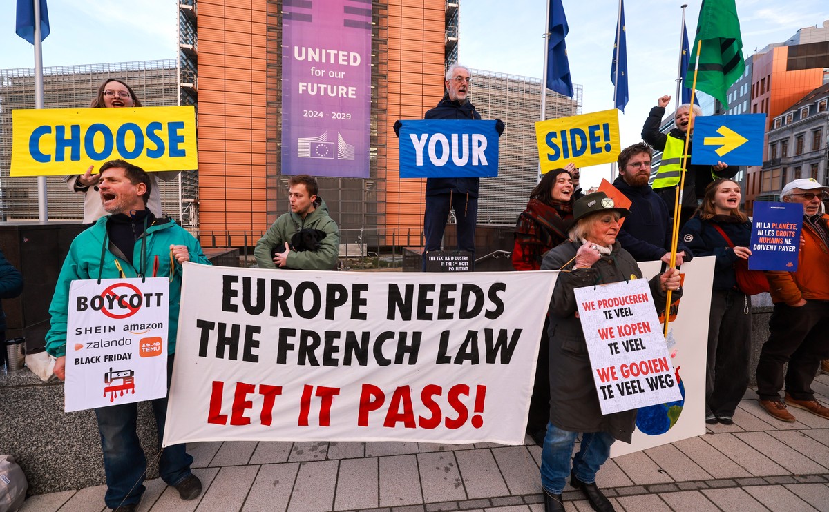epa12652837 Activists hold placards and banners as they demonstrate against fast fashion outside the European Commission headquarters in Brussels, Belgium, 16 January 2026. Activists are calling on th ...