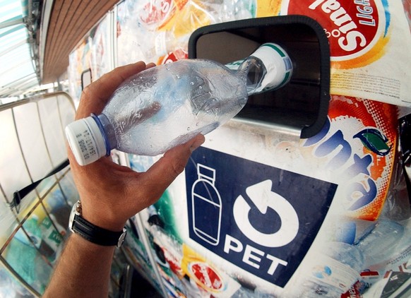 Eine Pet Flasche wird am Freitag, 8. Juli 2004, an einer Sammelstelle in Zuerich in einen Container geworfen. Im Rahmen eines Pet-Forums in Zuerich wurde heute ueber die Moeglichkeit der Einfuehrung e ...