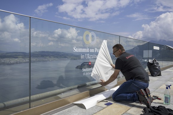 A worker prepares the logo of the peace summit in Buergenstock, Switzerland, Thursday, June 13, 2024. A Ukraine peace simmit with over 90 delegations from all over the world will take place at the Bue ...