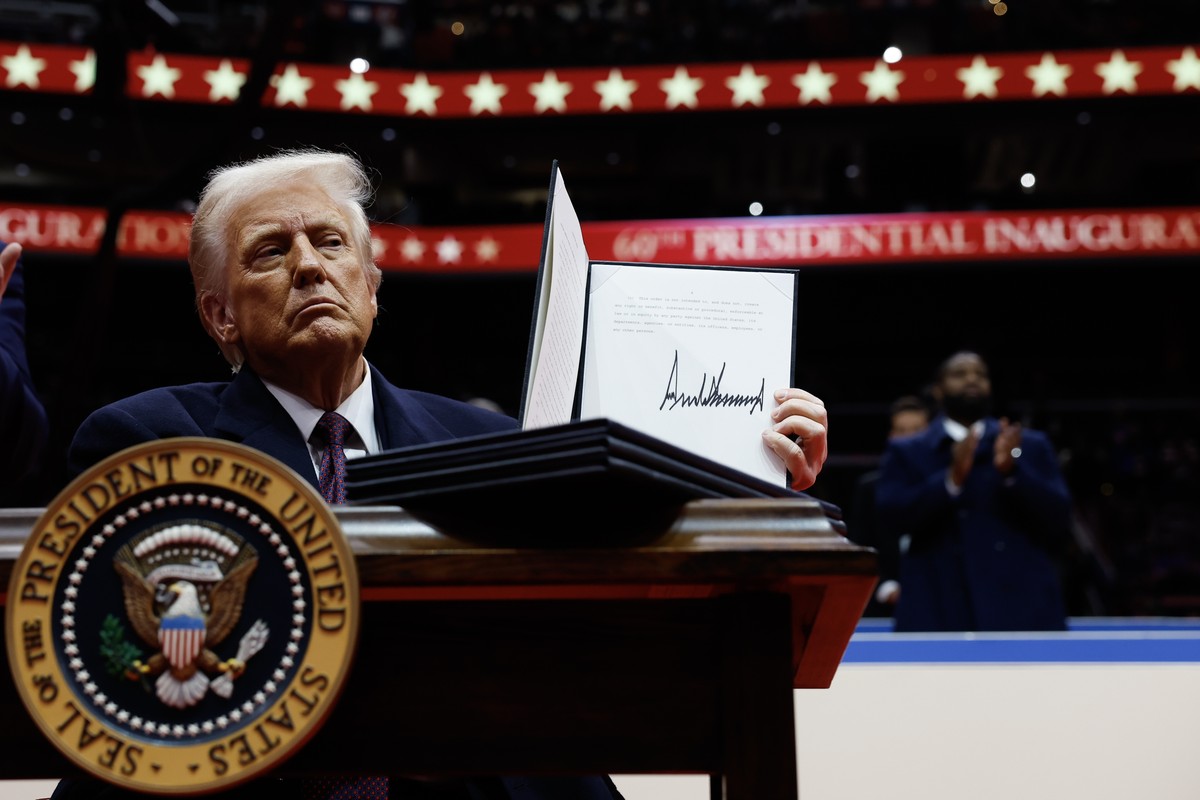 epa11840740 U.S. President Donald Trump holds up an executive order after signing it during an indoor inauguration event at the Capital One Arena in Washington, DC, USA, 20 January 2025. Trump was swo ...