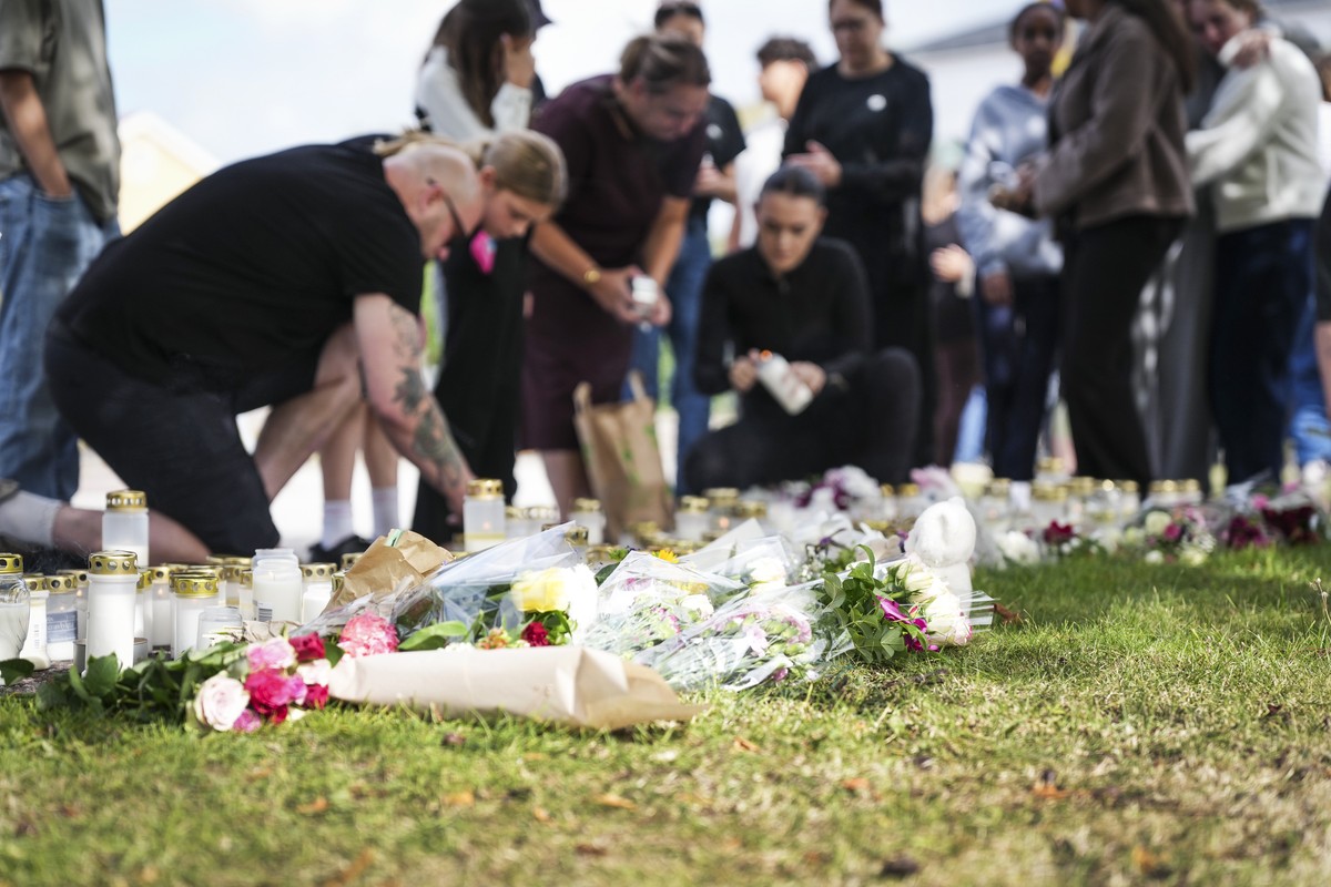 epa13184008 People leave flowers and candles at a makeshift memorial outside a school, one day after an attack carried out by a man with a sword in Fagersta, Sweden, 22 August 2026. A 17-year-old girl ...