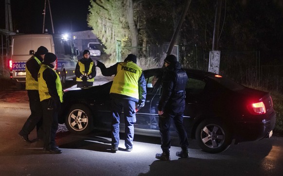 Police officers gather outside a grain depot in Przewodow, eastern Poland, on Tuesday Nov. 15, 2022 where the Polish Foreign Ministry said that a Russian-made missile fell and killed two people. The m ...