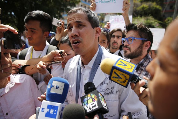 Opposition National Assembly President Juan Guaido, who declared himself interim president of Venezuela, speaks to reporters during a walk out against President Nicolas Maduro, in Caracas, Venezuela,  ...