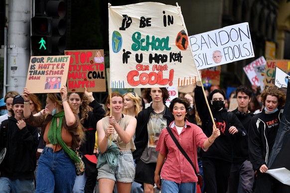 epa09848103 School students hold placards during a Climate School Strike protest at Treasury Gardens in Melbourne, Australia, 25 March 2022. EPA/JOEL CARRETT AUSTRALIA AND NEW ZEALAND OUT