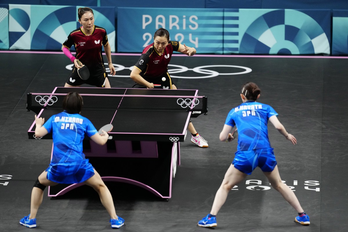 Germany's Yuan Wan, background right, and Xiaona Shan play against Japan's Hina Hayata and Miu Hirano during the women's teams semifinal table tennis match at the 2024 Summer Olympics,  ...