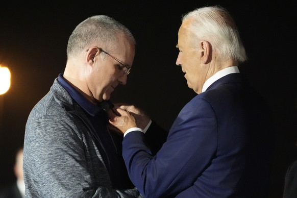 President Joe Biden, right, places his American flag pin on Paul Whelan at Andrews Air Force Base, Md., following Whelan&#039;s release as part of a 24-person prisoner swap between Russia and the Unit ...