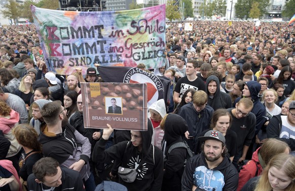 epa06994716 Concert-goers stand with their banners in front of a stage in Chemnitz, Germany, 03 September 2018. German music groups offer a free concert to support the civil society in Chemnitz. After ...