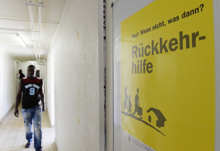 Ein Plakat mit der Aufschrift &quot;Asyl: Wenn nicht, was dann? Rueckkehrhilfe&quot; haengt an der Wand eines Ganes im Asylzentrum Juch AOZ, aufgenommen am Mittwoch, 11. Juni 2014, in Zuerich. Seit An ...