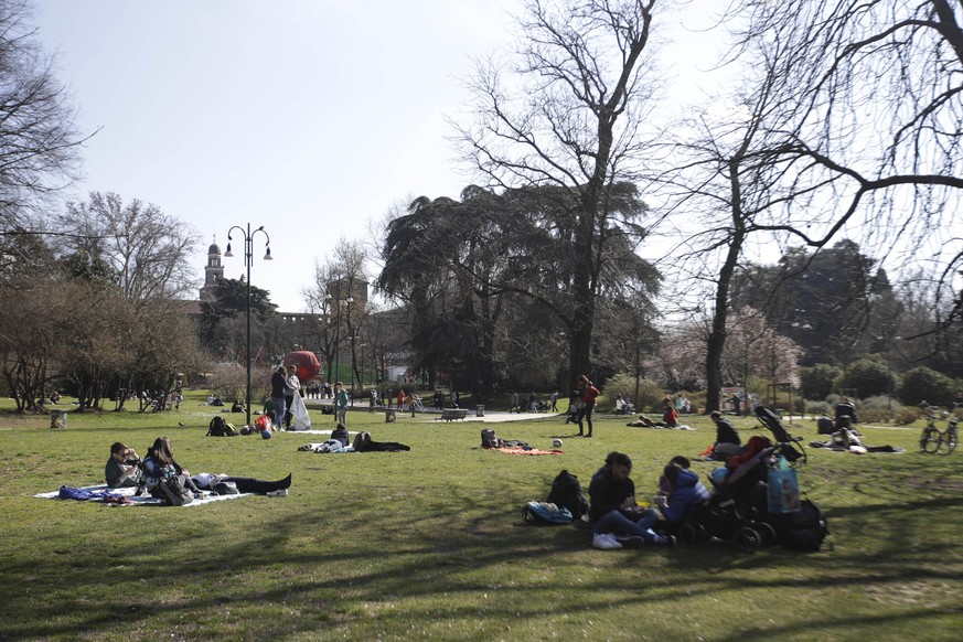 People relax at Sempione park, in Milan, Italy, Sunday, March 8, 2020. Italy announced a sweeping quarantine early Sunday for its northern regions, igniting travel chaos as it restricted the movements ...