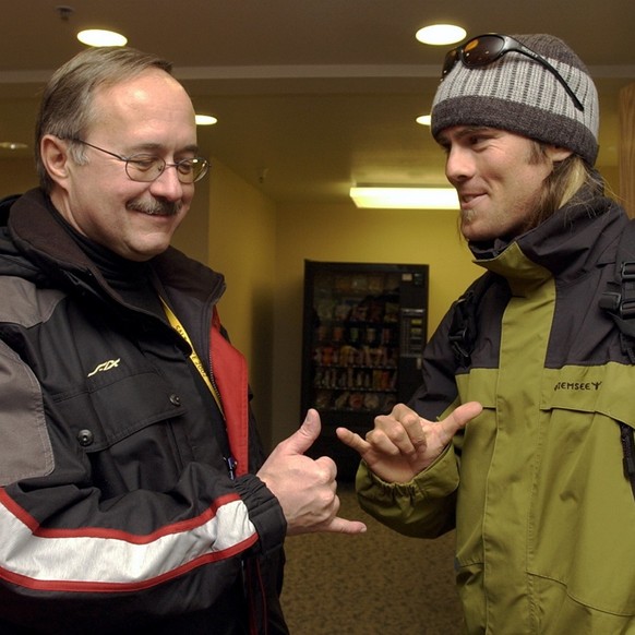 Der Snowboarder Ueli Kestenholz, rechts, versucht Bundesrat Samuel Schmid am Donnerstag, 7. Februar 2002, im Olympischen Athletendorf von Salt Lake City den lockeren Snowboarder-Gruss beizubringen. (K ...