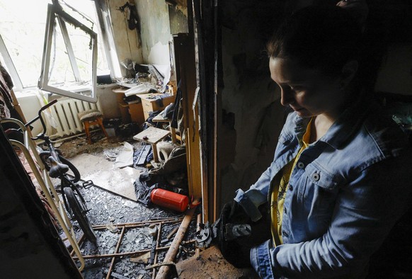 epa12129852 A resident handles drone debris inside her damaged flat in a five-storey residential building struck by a drone in Kyiv, Ukraine, 24 May 2025, amid the ongoing Russian invasion. Nobody was ...