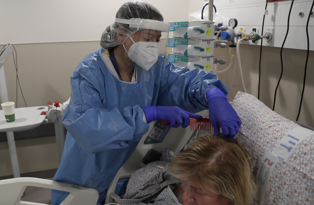 epa09689412 Staff combs the hair of a patient at the ICU's Covid-19 department at Ziv Hospital, in Zefat, Israel, 16 January 2022. According to Israeli health and educations ministry, the nationa ...