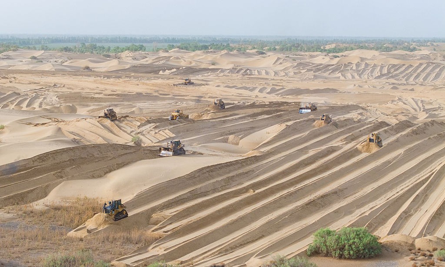 BAZHOU, CHINA - MAY 22, 2025 - Large-scale machinery is leveling sand dunes in the area of the sand prevention and control project on the northern edge of the Taklimakan Desert in Bayingolin Mongolian ...