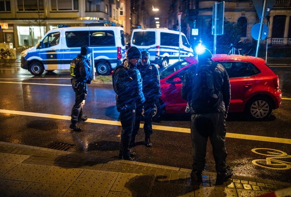10.03.2023, Baden-W�rttemberg, Karlsruhe: Polizeieinheiten stehen an einer Polizeiabsperrung nachdem es in einer Apotheke zu einer mutma�lichen Geiselnahme gekommen war. Die Geiselnahme in Karlsruhe i ...